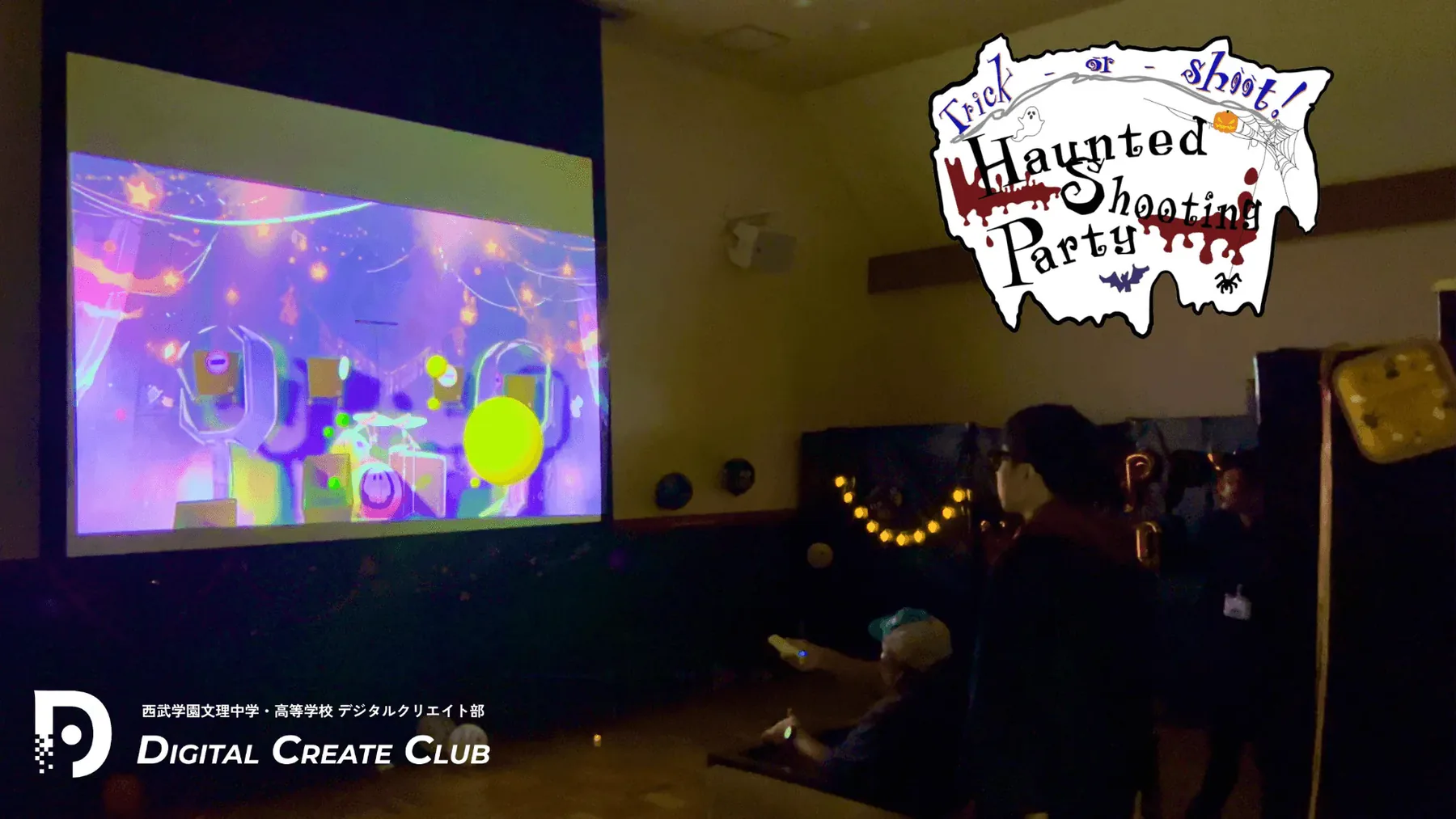 投影スクリーンの前で端末を構える来場者とHaunted Shooting Partyのロゴ