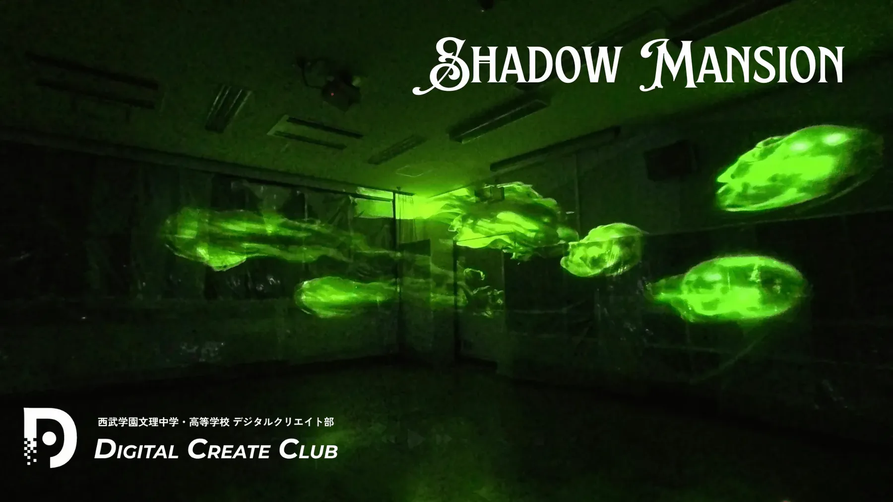 暗い室内の壁面に緑色の顔が浮かぶShadow Mansionの投影演出